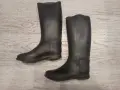 Para czarnych gumowych kaloszy jeździeckich na jasnym, drewnianym tle.
